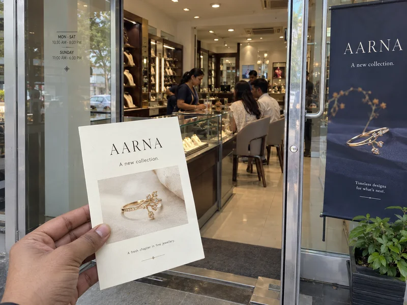 Concept jewellery shop entrance with a matching printed collection invitation in hand